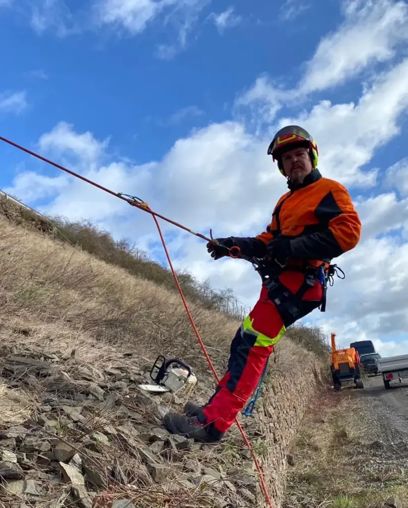 Heinrich Kath seilgesichert bei der Böschungspflege am Steilhang