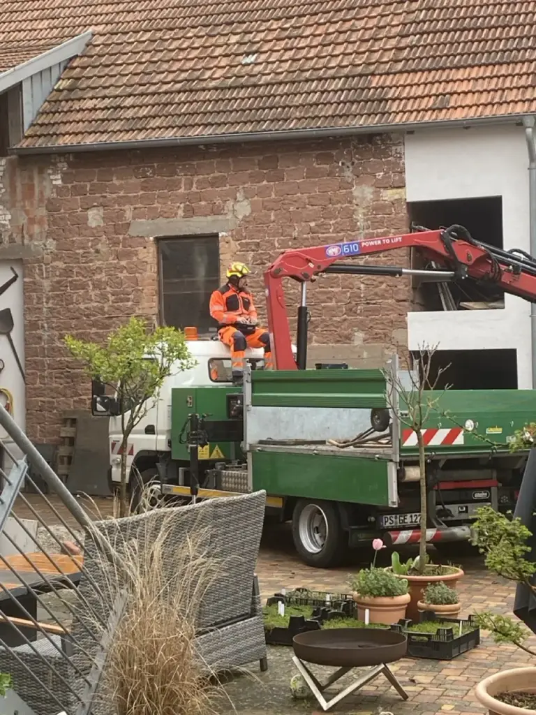 Arbeiten mit dem Ladekran auf einem Hofgelände
